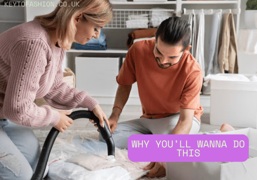 How to Build a Capsule Wardrobe That Works Without Losing Your Mind 2 A fair-skinned woman with blonde hair, wearing a light pink sweater and light blue jeans, is vacuuming clothes laid out on a light-colored rug. A fair-skinned man with dark hair, wearing an orange t-shirt and light grey pants, sits nearby watching her. They appear to be organizing a Capsule Wardrobe. The background shows a white shelving unit with folded clothes and storage boxes. A purple banner with white text reads "WHY YOU'LL WANNA DO THIS".
