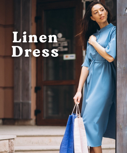 How to Rock Linen Dress Outfits for Summer 2025 2 A stylish woman with long, brown hair is standing in front of a store entrance, holding several shopping bags. She is wearing a knee-length, light blue linen dress with a cinched waist and a button-up front. The text "Linen Dress" is superimposed on the left side of the image in a large, white, serif font.