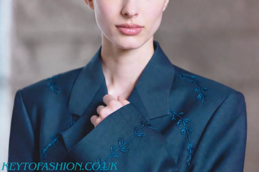 Why High-Quality Hand Embroidery Is Your Best Investment 3 Close-up of a dark teal professional blazer with subtle tone-on-tone hand embroidered style (leaf pattern) on the collar and sleeve, illustrating quiet luxury office fashion.