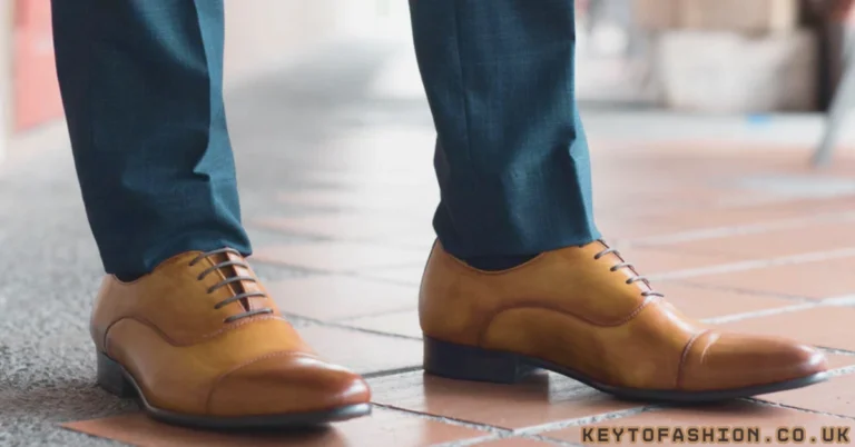 The 10 Best Tan Leather Shoes For Men Right Now Expert-Tested Picks 7 A close-up of light brown leather cap-toe Oxford shoes paired with navy blue suit trousers, ideal for formal business attire.