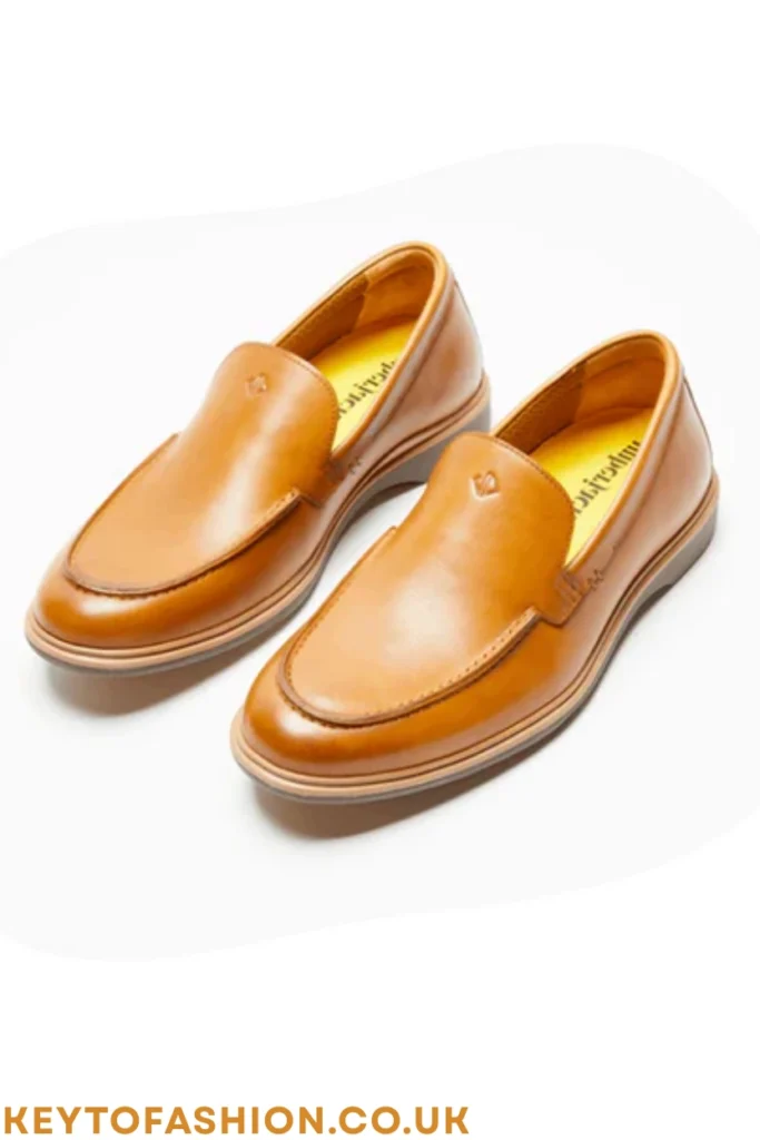 The 10 Best Tan Leather Shoes For Men Right Now Expert-Tested Picks 2 A pair of sleek tan leather shoes in a slip-on loafer style, featuring a plain toe and modern rubber sole, shot against a white background.